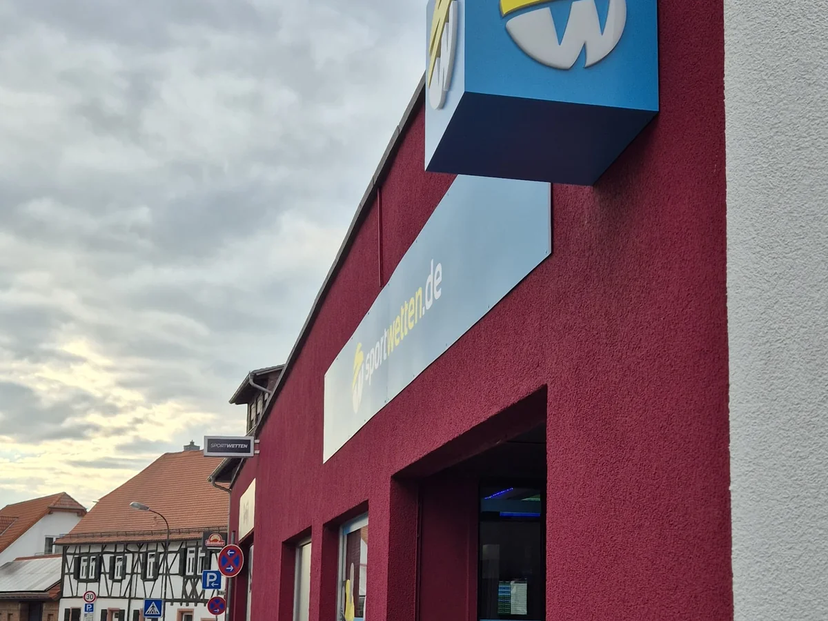 Beleuchteter Leuchtkasten eines Wettbüros bei Dämmerung — Lichtwerbung von Neue Außenwerbung